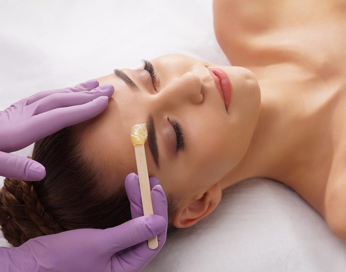 Beautician,Is,Removing,Hair,From,Beautiful,Female,Face,With,Hot